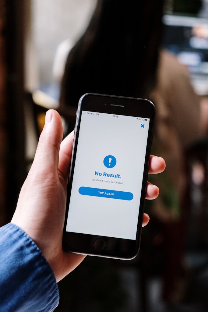 Hand holding a smartphone displaying a 'No Result' notification, emphasizing technology usage.